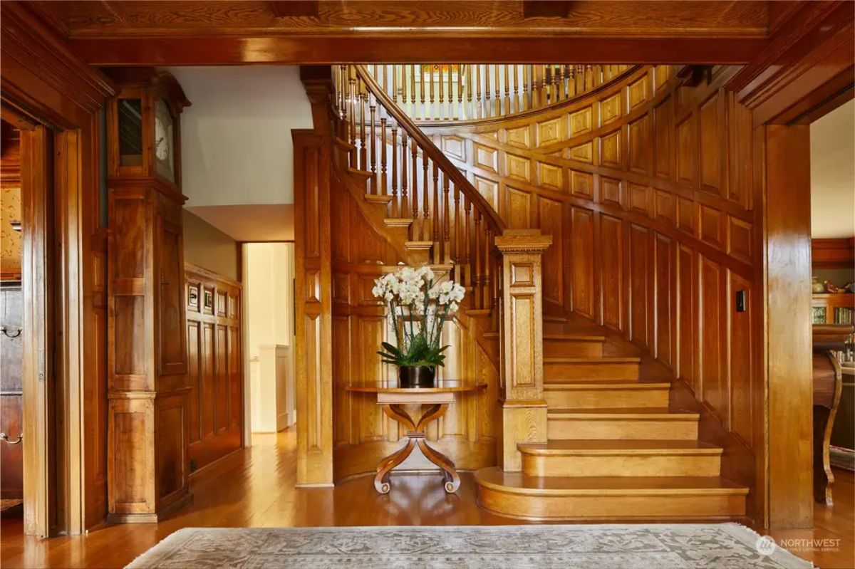 Curved staircase showcases rich wood paneling and detailed craftsmanship.