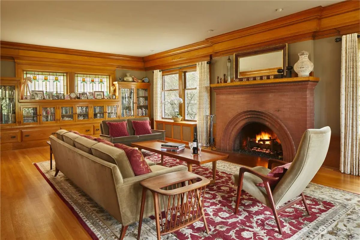 Living room centers around a large brick fireplace with an arched design and wooden mantel.