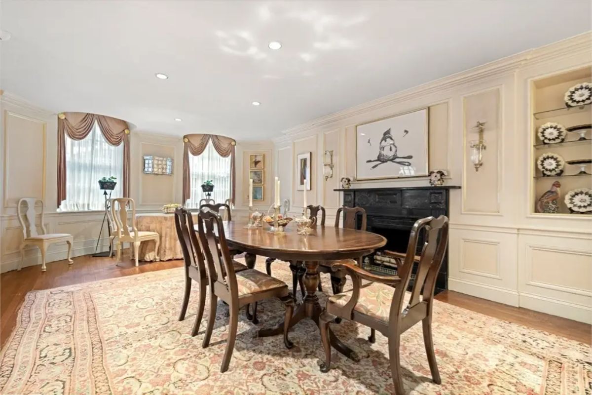 A polished wooden dining table and chairs set atop an intricate area rug.
