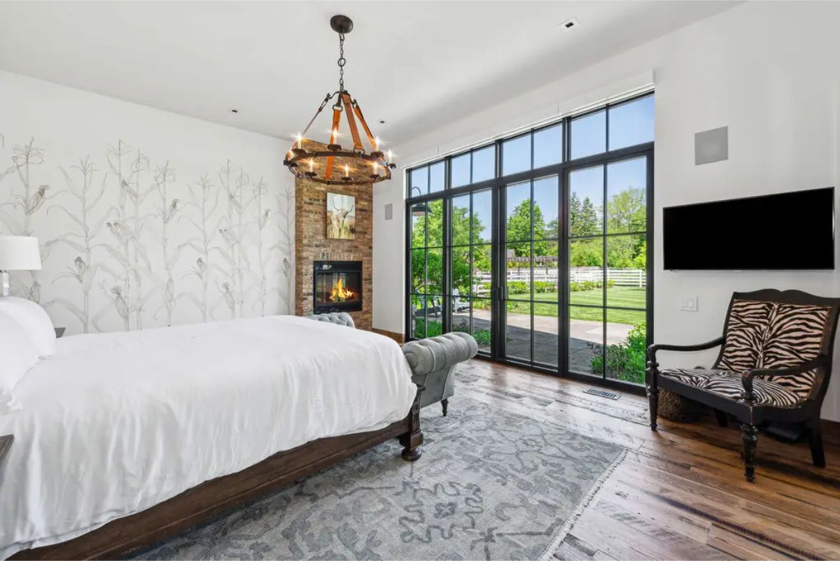 Master bedroom offering floor-to-ceiling windows that provide breathtaking views of the surrounding property.