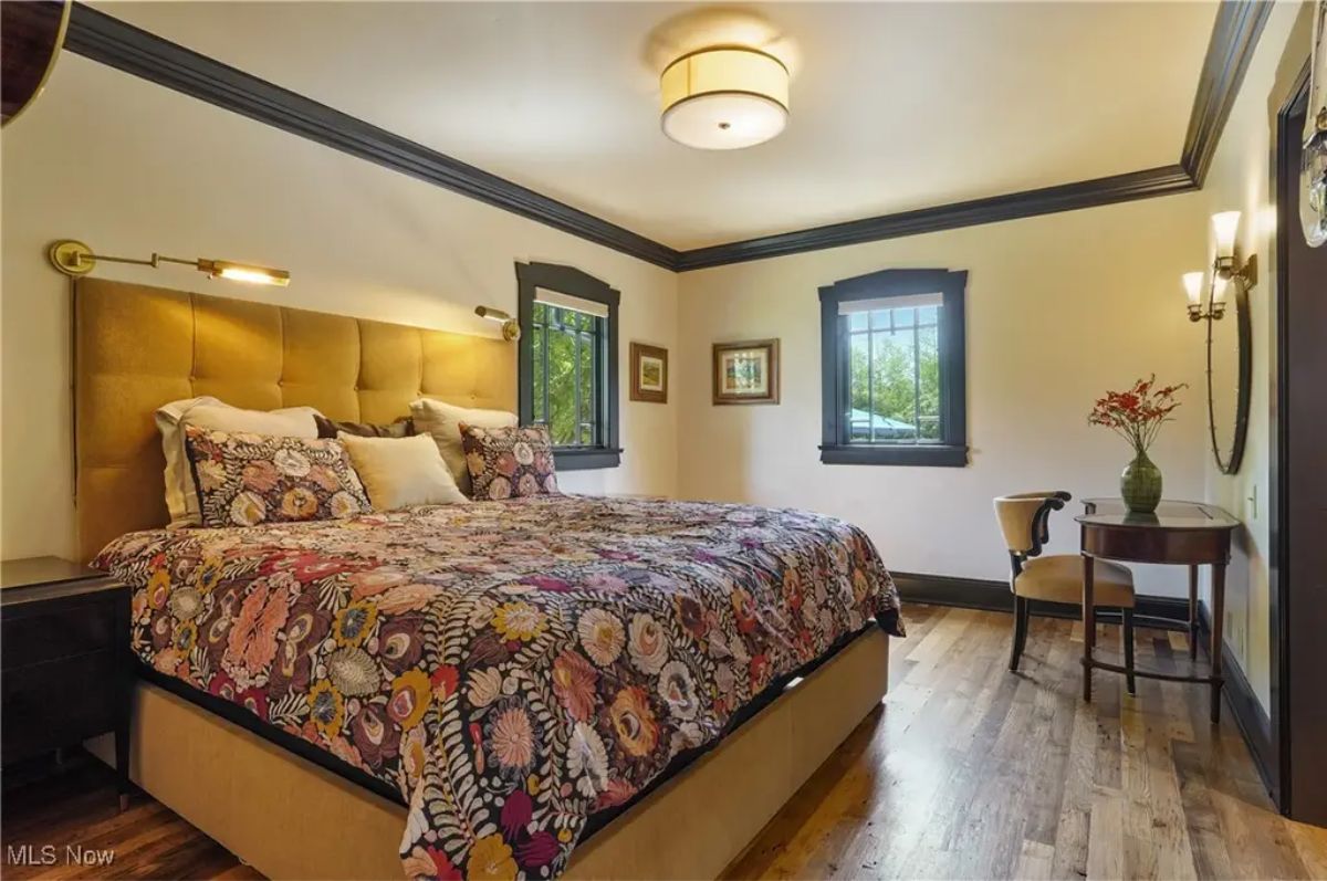Tufted mustard-colored headboard paired with a floral-patterned bedspread, creating a warm and inviting atmosphere.