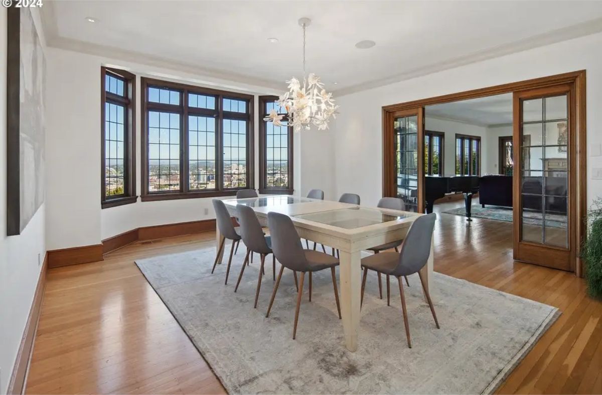 Dining room features a large bay window with wood framing, offering panoramic city views.