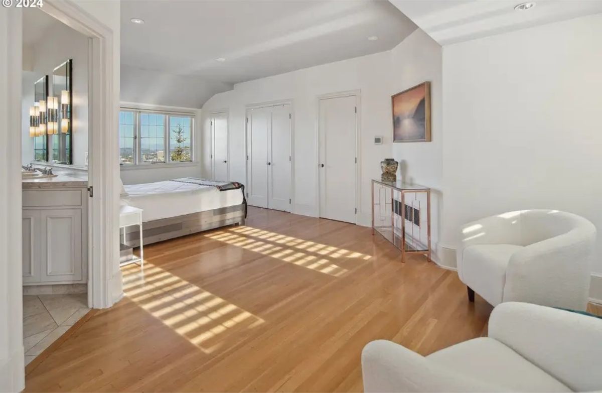 Clean white walls, hardwood floors, and large windows with expansive views.
