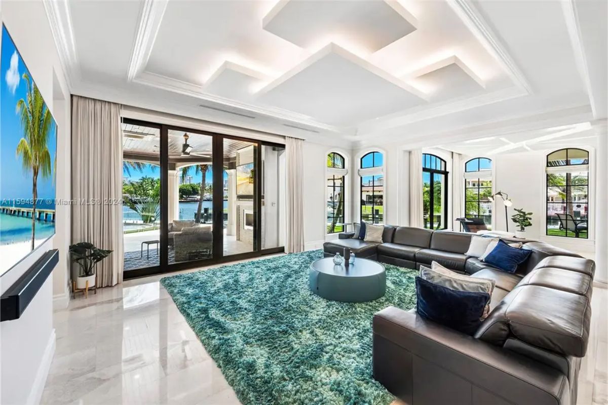 Spacious living area with a modern design, recessed lighting, and sliding doors opening to the patio. 