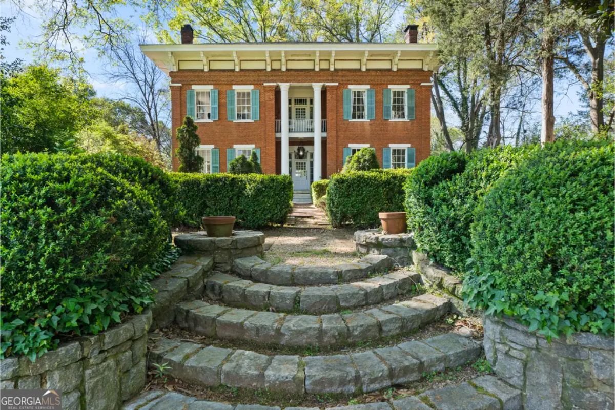 Priced at $1,195,000, Dixie Manor is a 5,228 sq ft, two-story antebellum brick home built in 1838, featuring 5 bedrooms, 5 bathrooms, 12-foot ceilings, 10 fireplaces, and original heart pine floors.