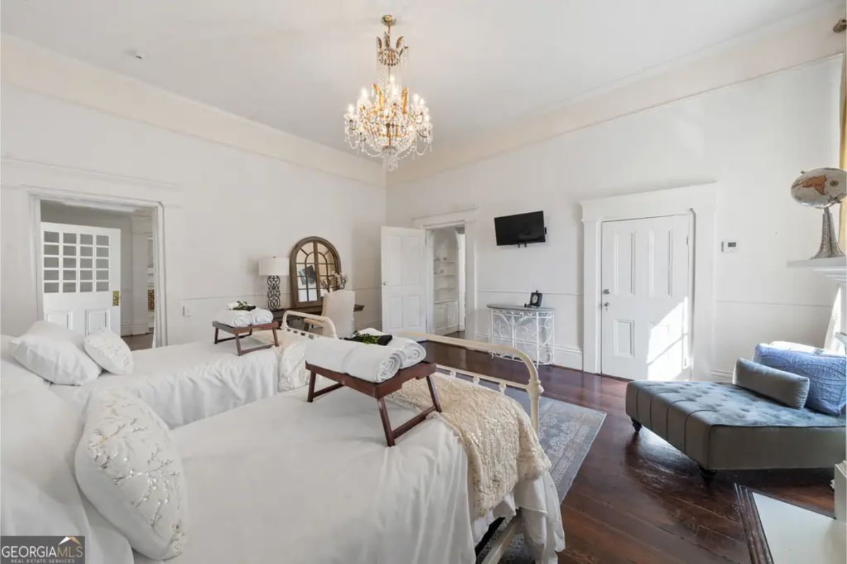 Two neatly arranged twin beds with crisp white linens and decorative throw pillows.