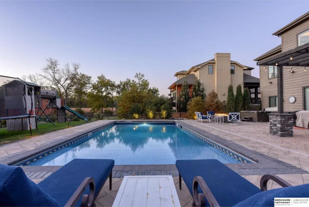 A rectangular in-ground pool surrounded by a spacious paver patio.