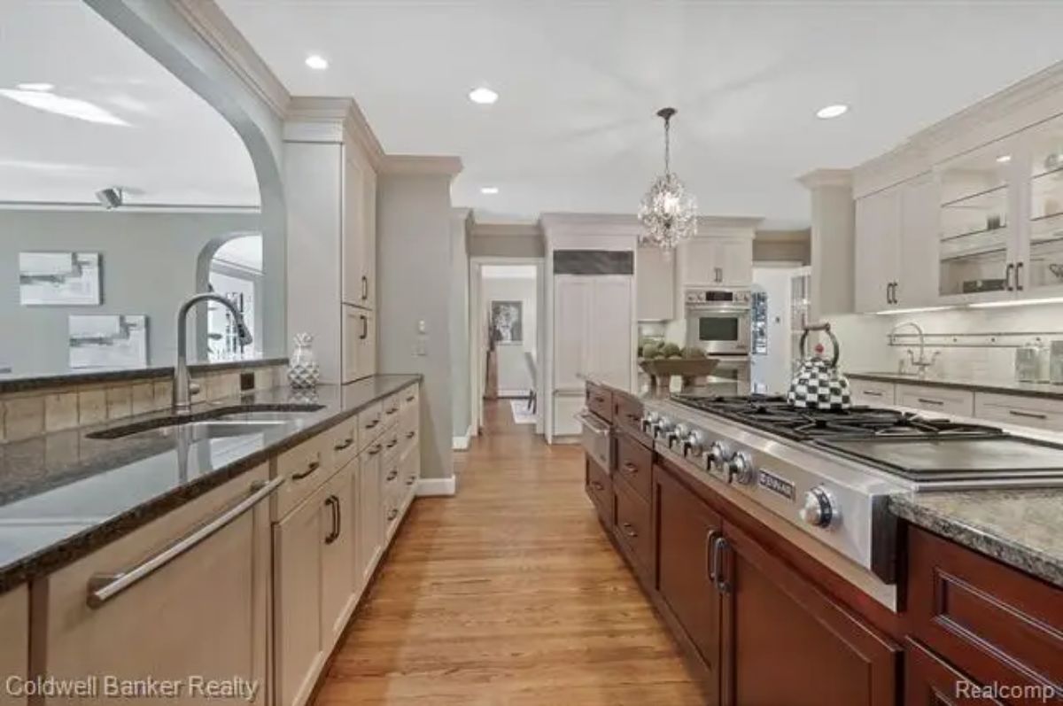 Kitchen features a central island with a gas cooktop and granite countertops.