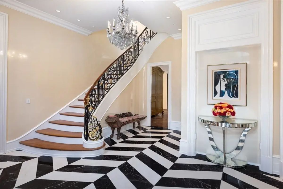 This sophisticated entryway features a striking black-and-white geometric marble floor that creates a bold visual statement.