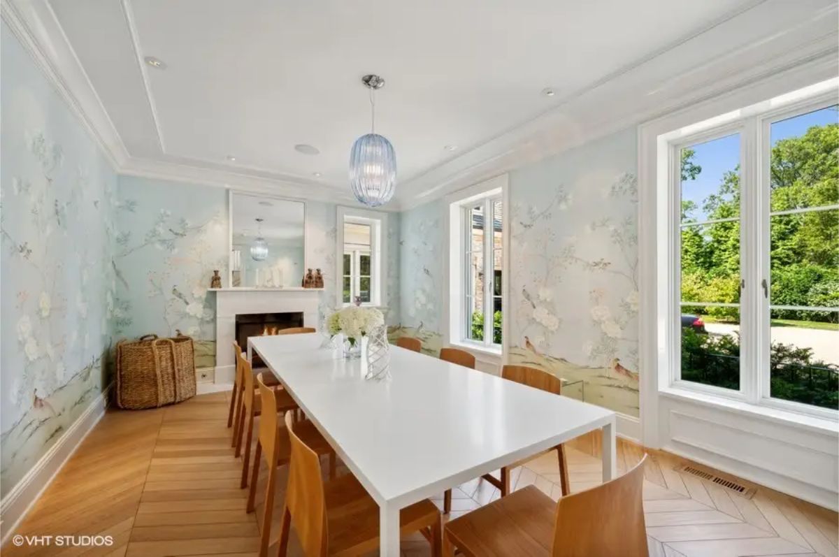 Light wood herringbone flooring and walls adorned with scenic floral wallpaper.