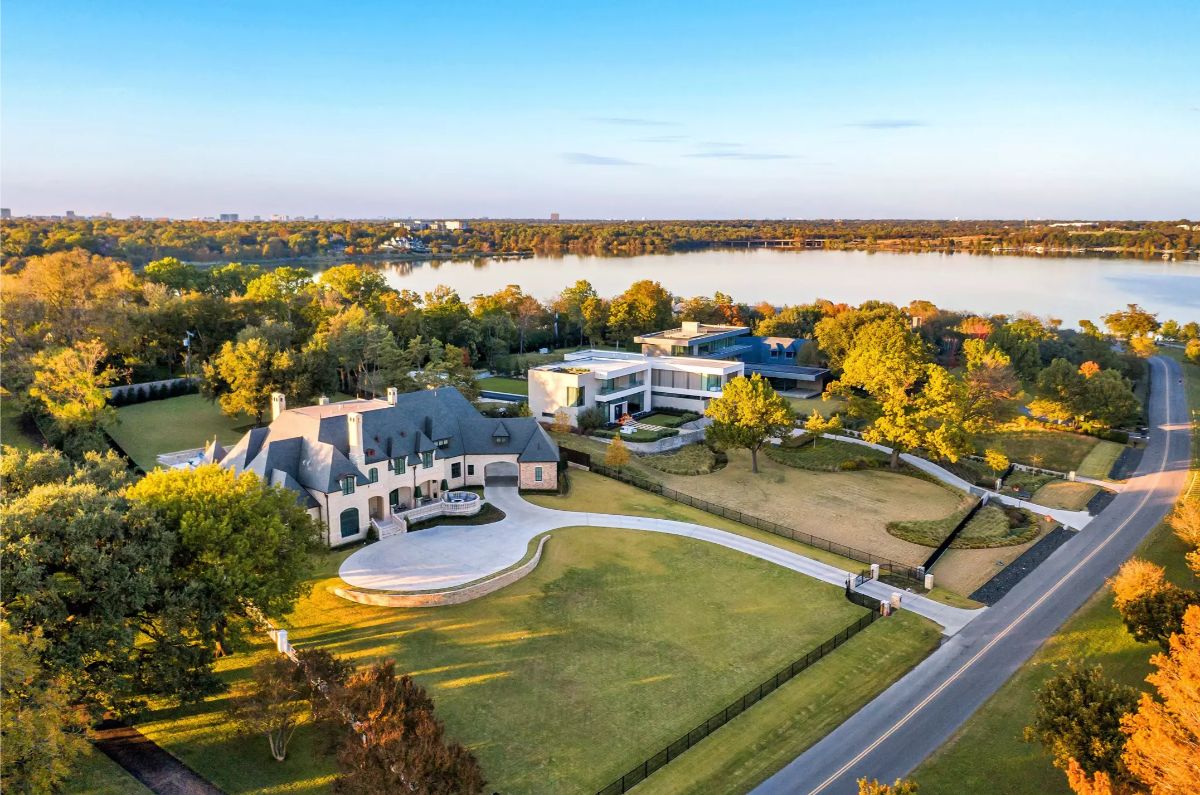 A bird's-eye view of a luxurious estate with a waterfront backdrop and adjacent modern and traditional homes.