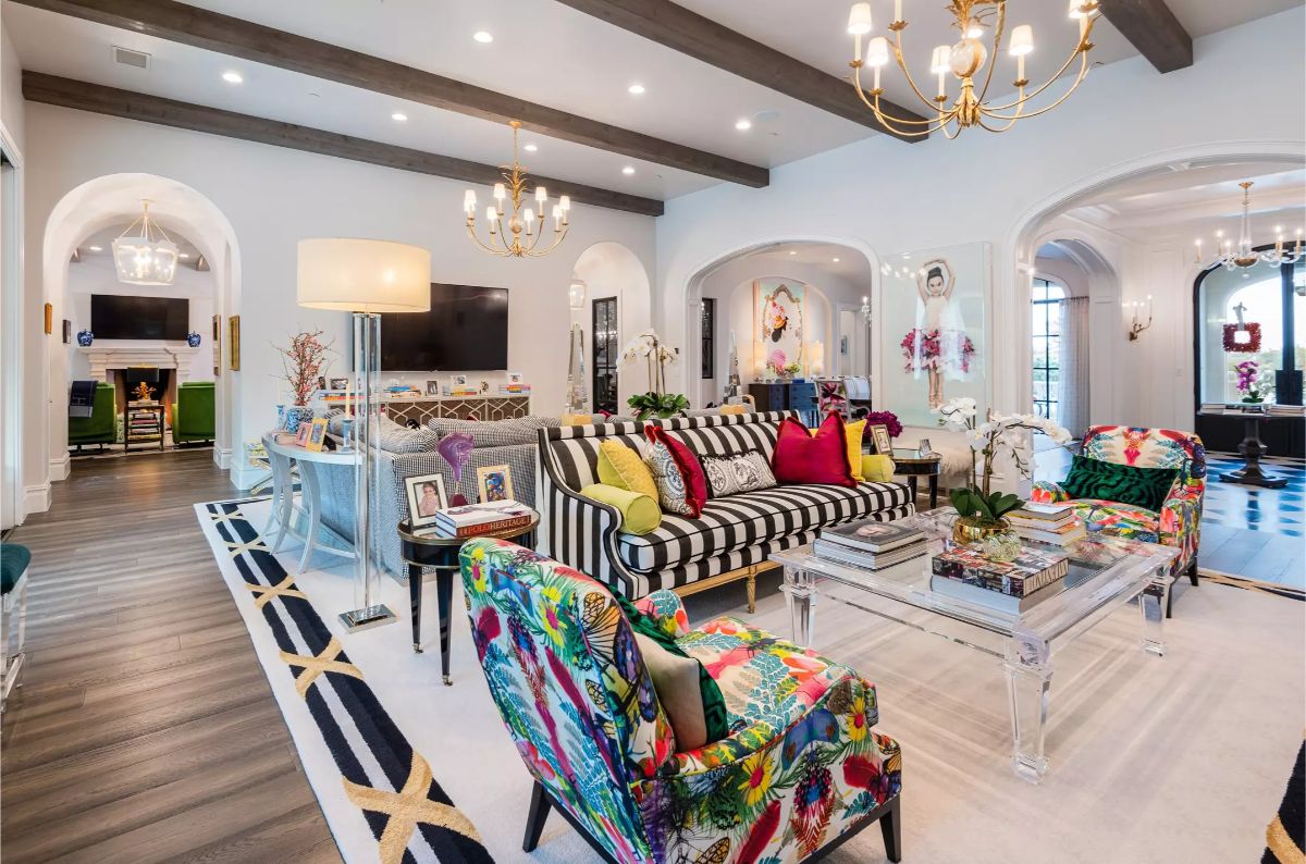 Bright living room with colorful furniture, striped upholstery, and modern chandeliers. 