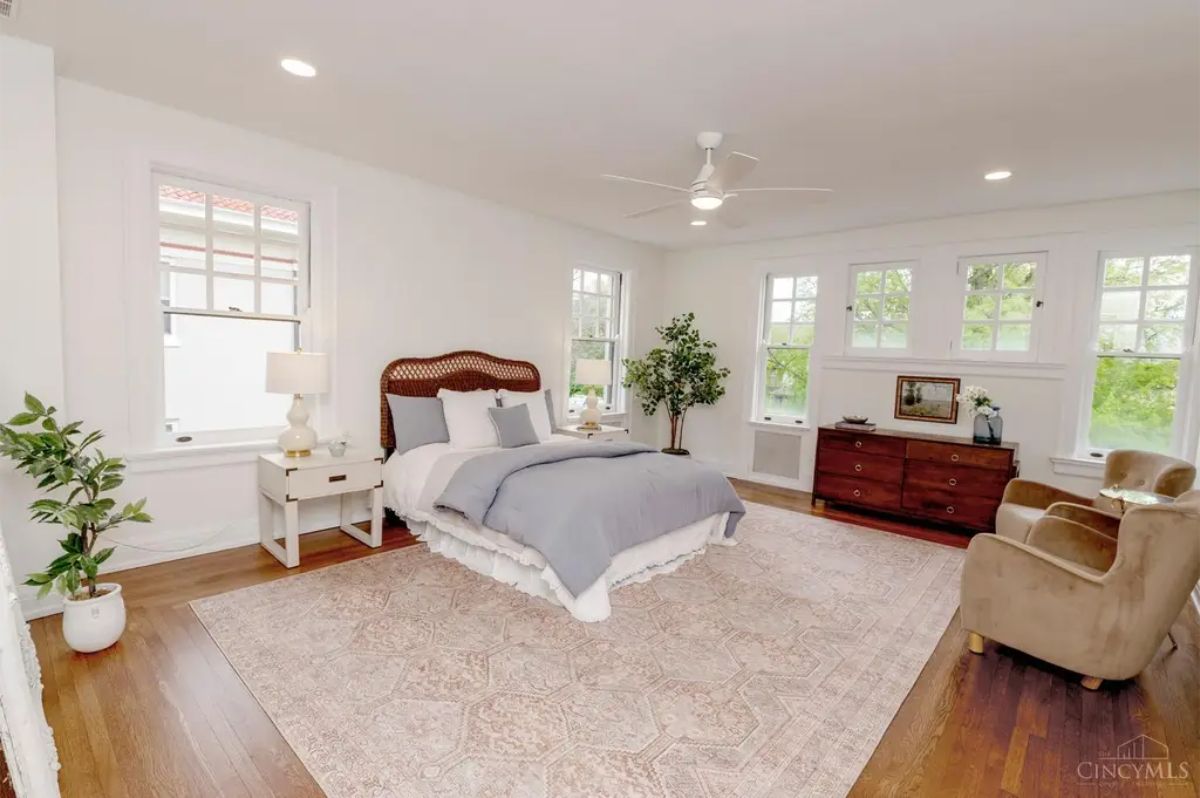 Large bedroom is highlighted by multiple windows that bring in abundant natural light, creating an airy atmosphere.