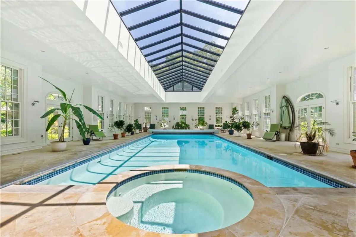 Indoor swimming pool with a glass ceiling and large windows allowing natural light. 