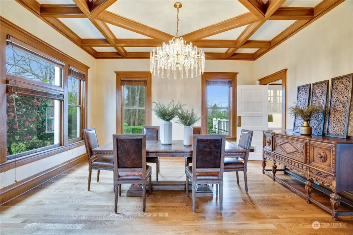 A coffered ceiling with rich wood trim and a central crystal chandelier.