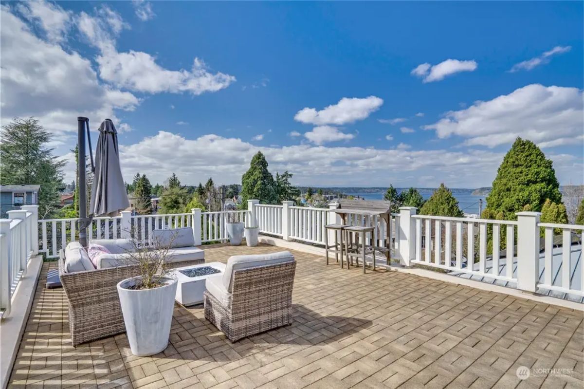 Rooftop terrace offers panoramic views of the surrounding trees, homes, and water.