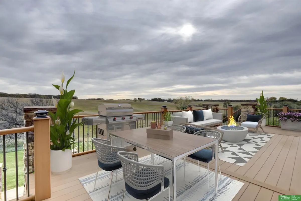 Outdoor deck featuring a dining area, comfortable seating, and a built-in grill for entertaining.