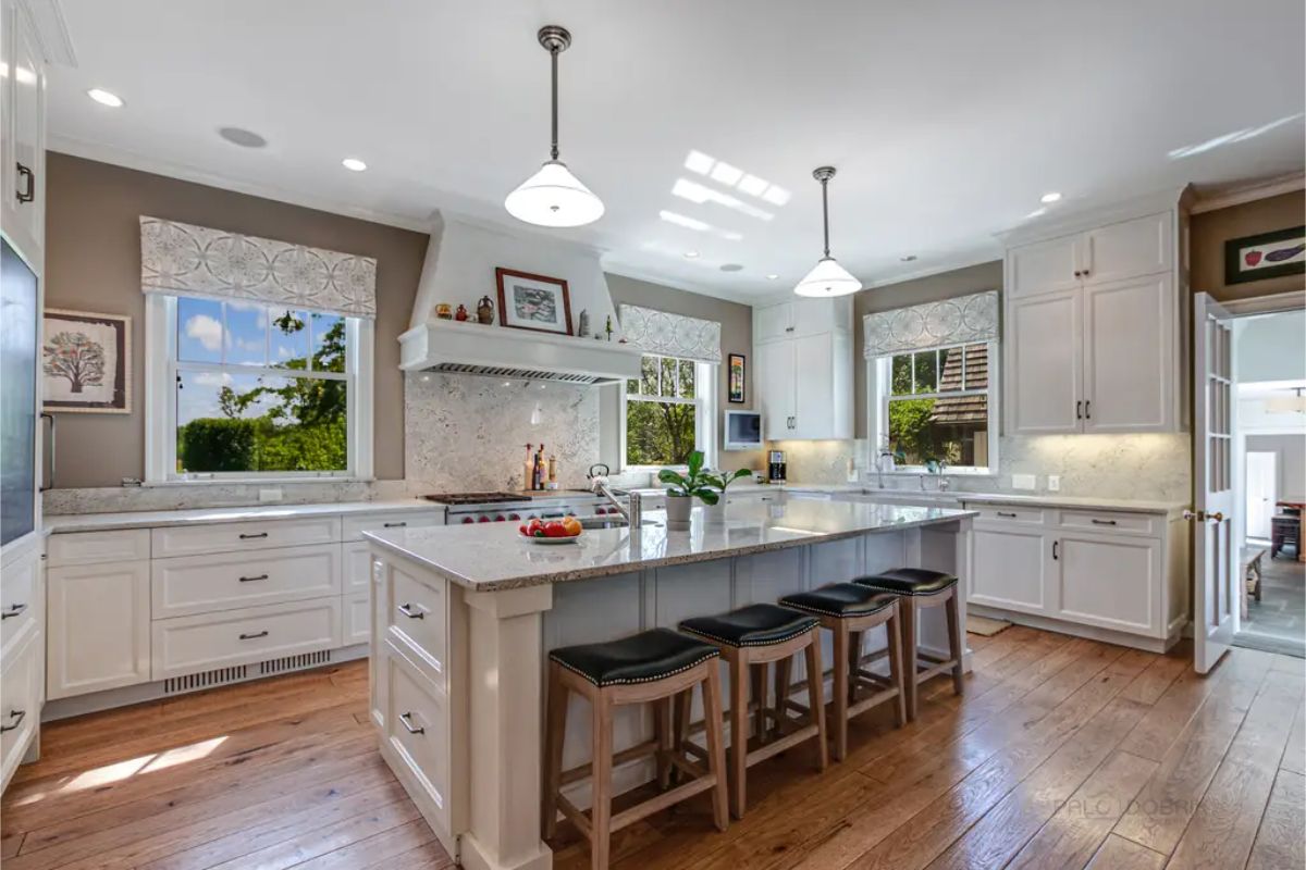 White cabinetry, granite countertops, and hardwood flooring.