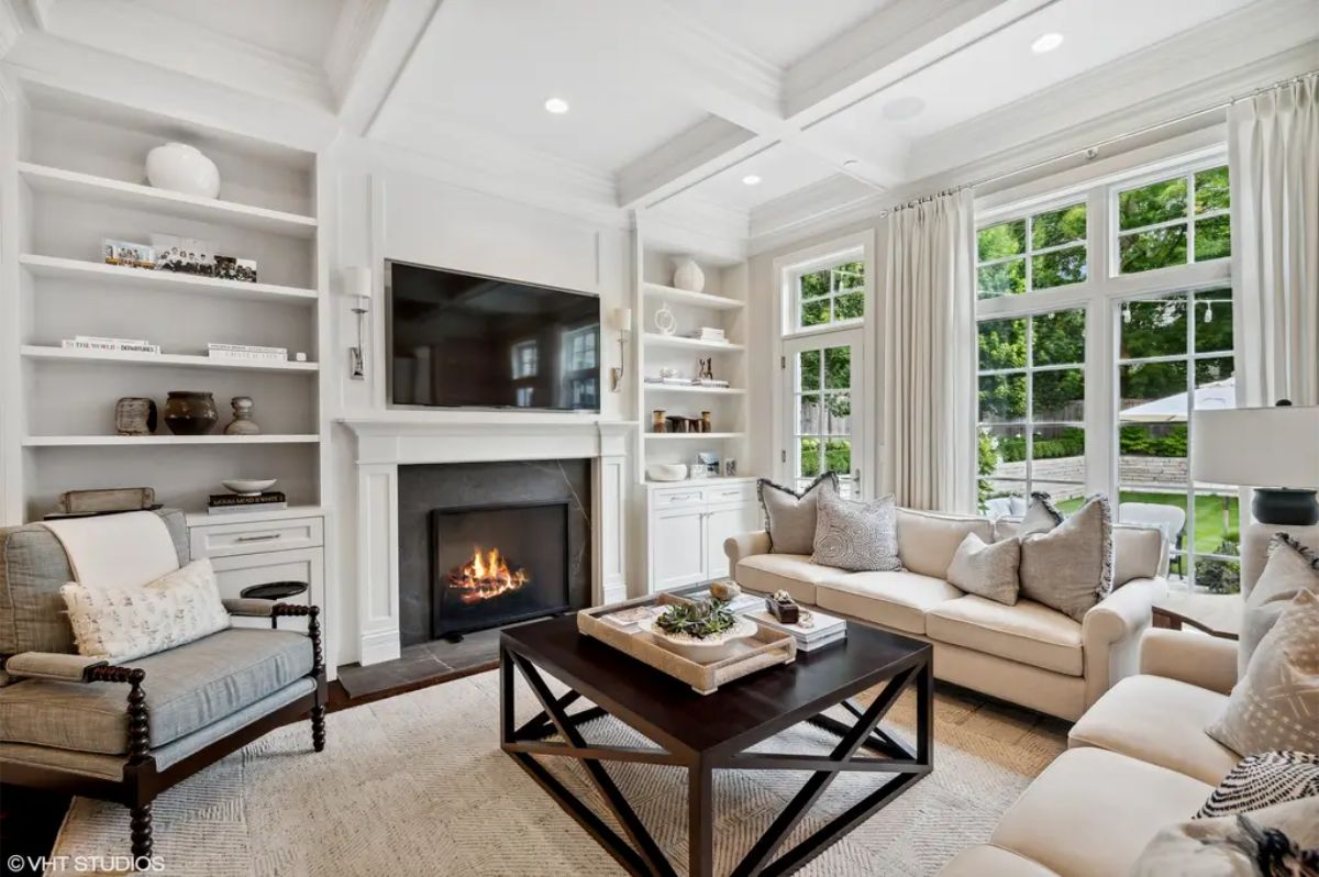 Airy living room with large windows overlooking a green backyard.