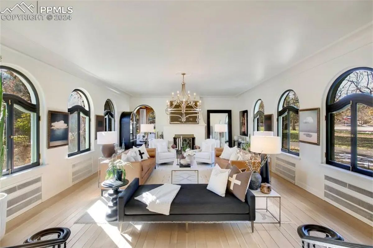 A series of arched windows that flood the space with natural light, offering picturesque views of the surrounding property.