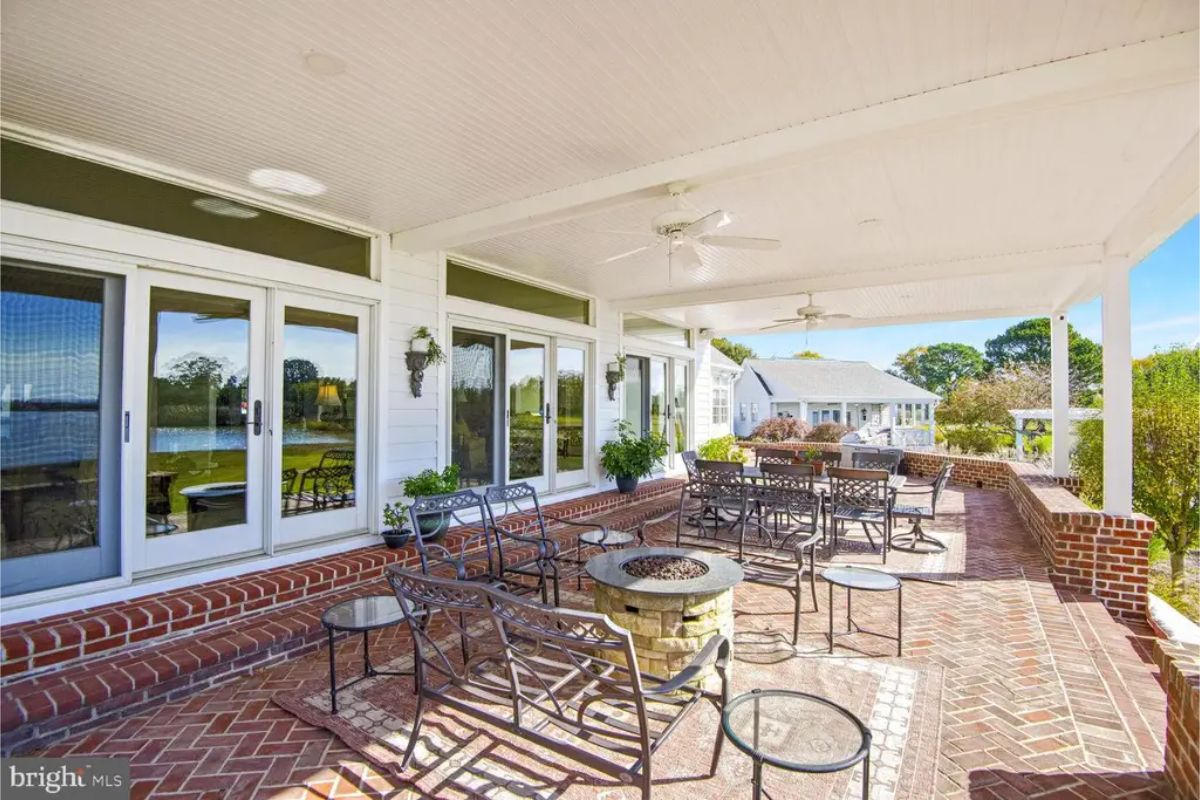 Outdoor patio with a white beadboard ceiling and ceiling fans for comfort.