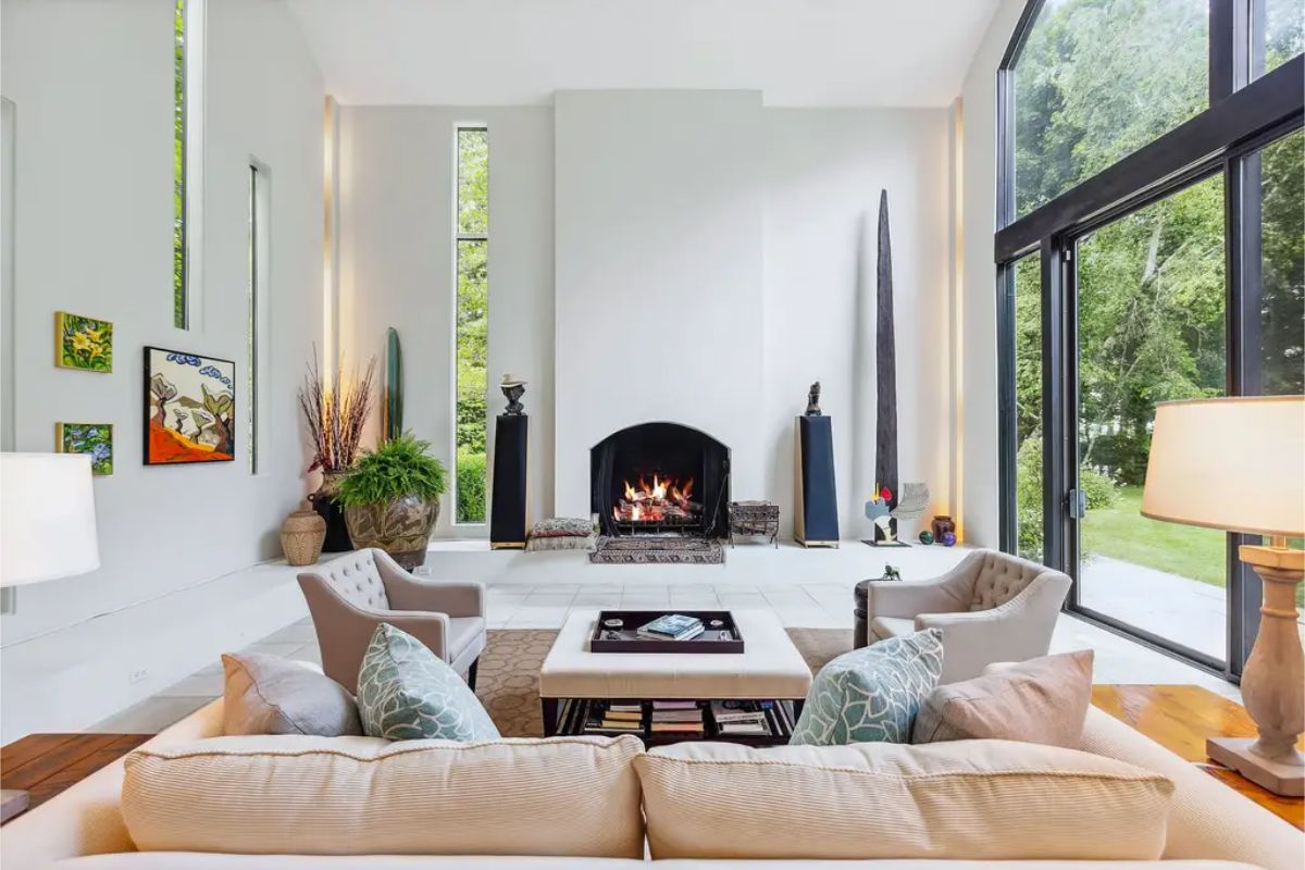 Showcases soaring ceilings with expansive glass walls framing lush outdoor views.