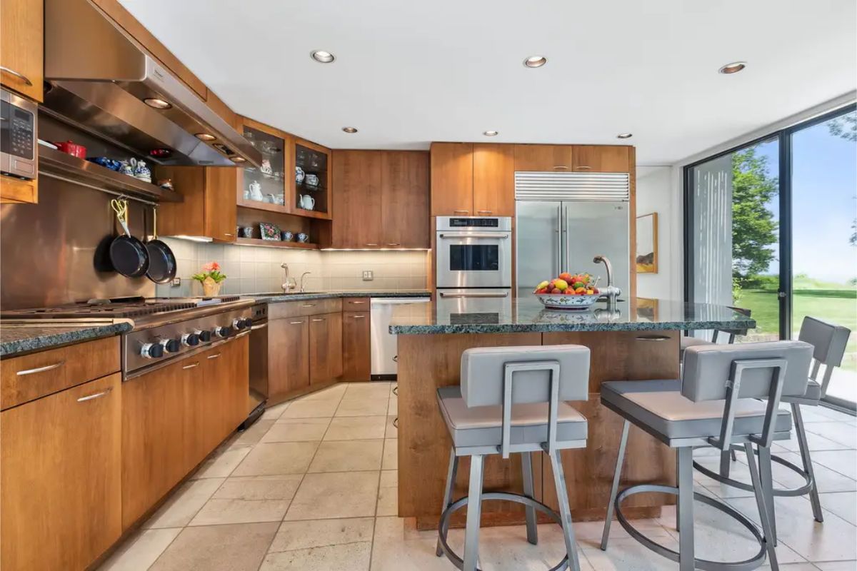 A sleek wood cabinetry, granite countertops, and high-end stainless steel appliances.