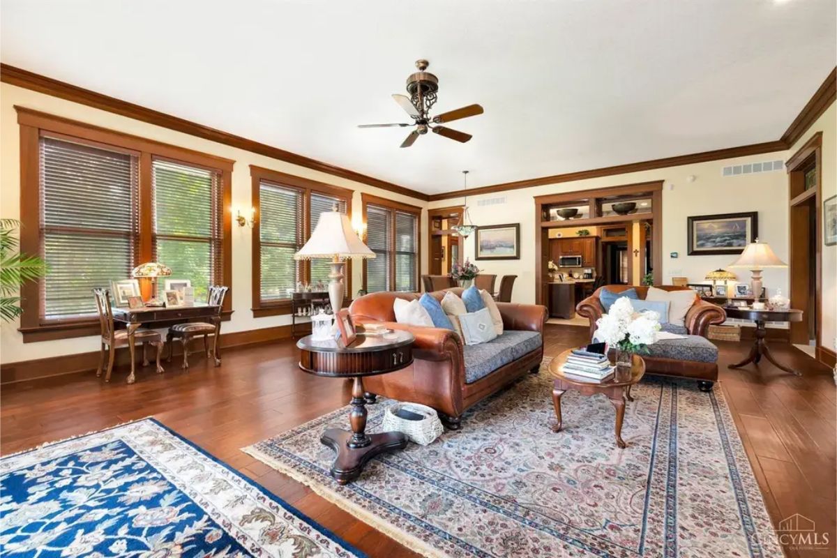 Large windows with wooden trim and blinds, allowing natural light to fill the space.