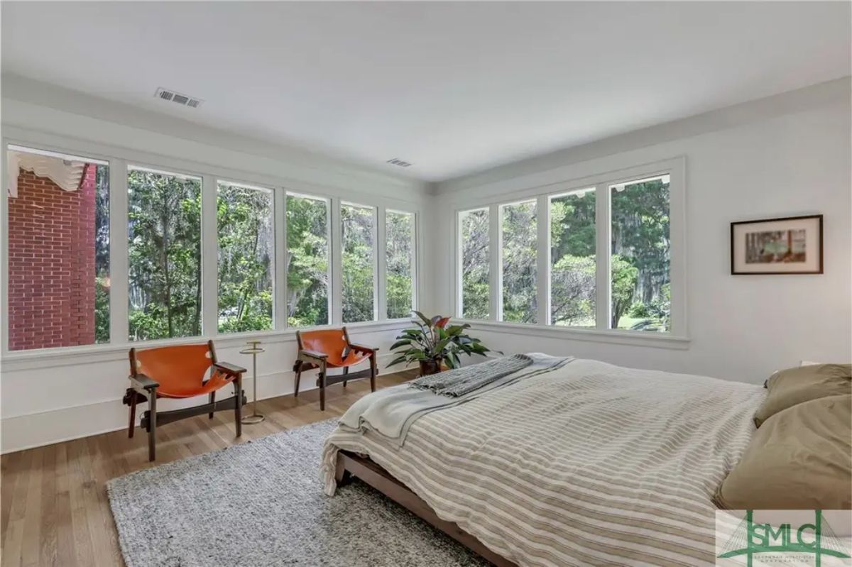 Expansive corner windows offering abundant natural light and scenic views of surrounding greenery.
