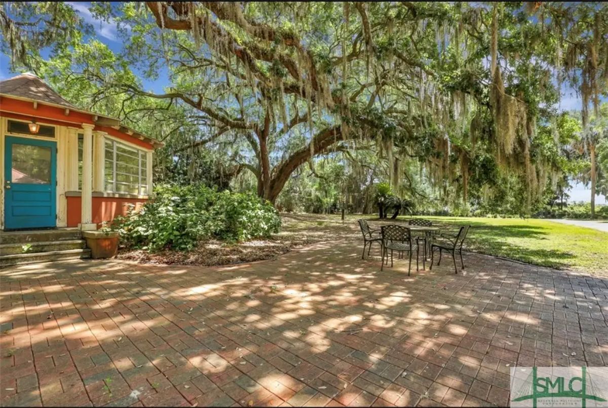Outdoor space features a spacious brick patio with a black metal table and chairs, ideal for alfresco dining.