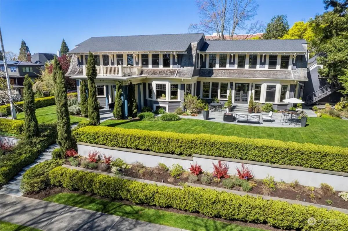 Renovated 1904 Queen Anne home offers 6 bedrooms and 6 bathrooms across 6,664 square feet. Main floor has an open gourmet kitchen, dining area, living room with fireplace, and access to outdoor spaces.