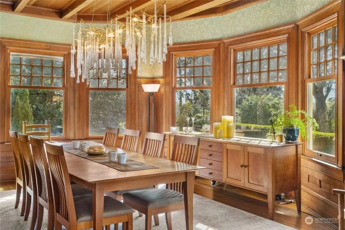 Expansive bay windows frame views of lush greenery and flood the room with light.