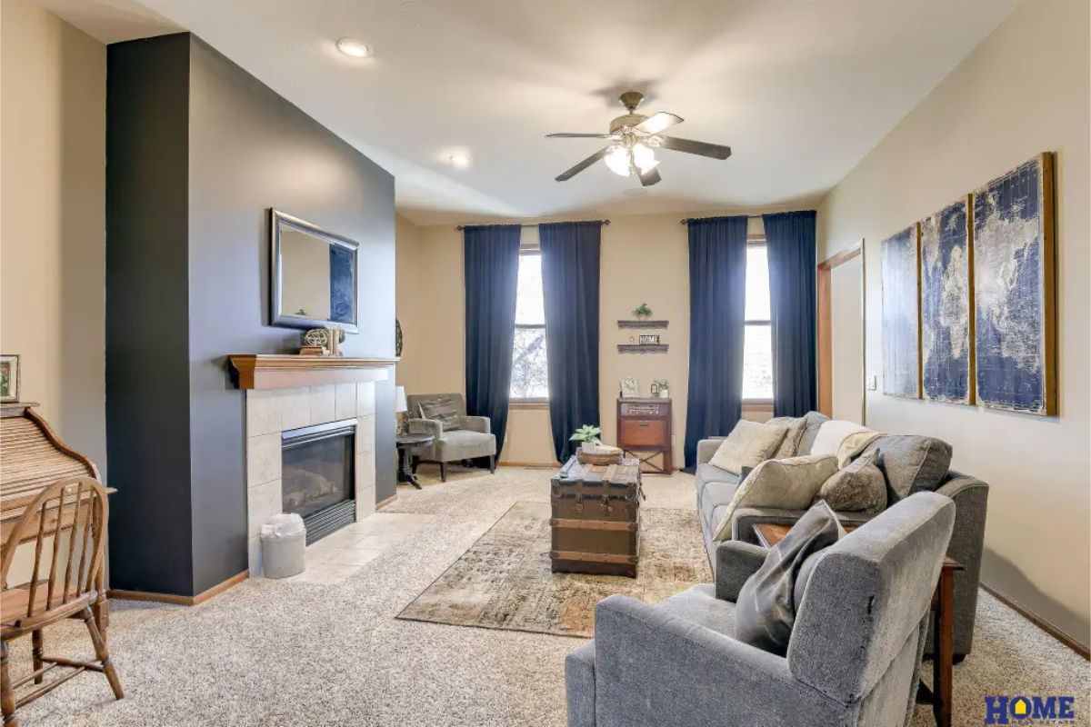 Living room designed with a central fireplace featuring a tiled surround and a wooden mantel.
