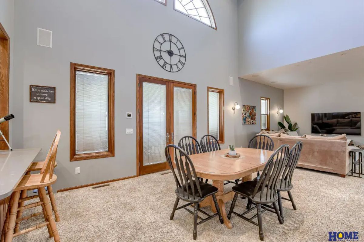 Dining area with a vaulted ceiling and large arched window for natural light.
