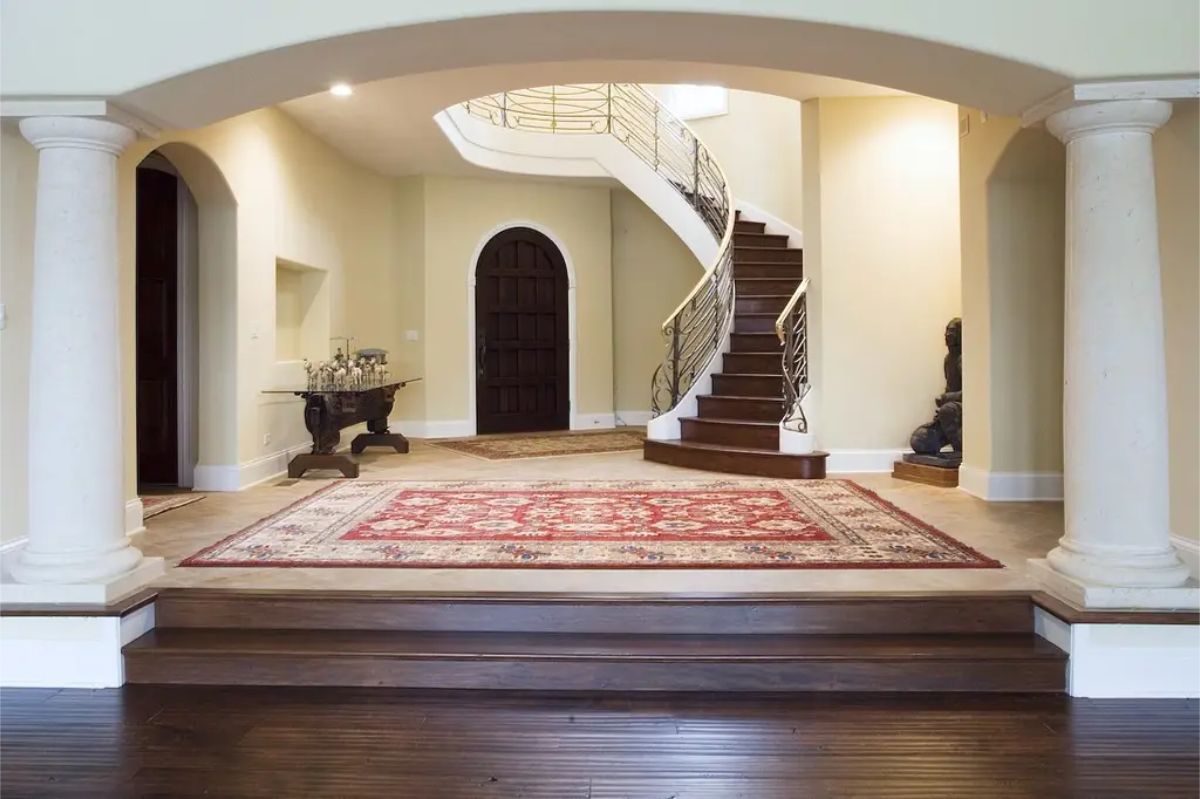 A curved staircase with a polished wood finish and ornate railings, creating a dramatic focal point.