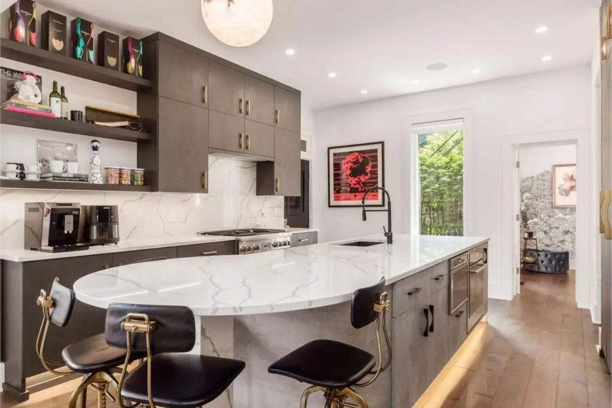 Dark cabinetry with gold hardware and open shelving for added functionality.