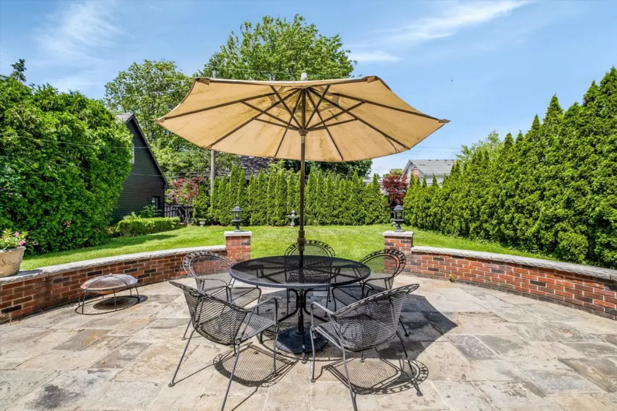 A stone patio offers a comfortable space for outdoor relaxation and dining.