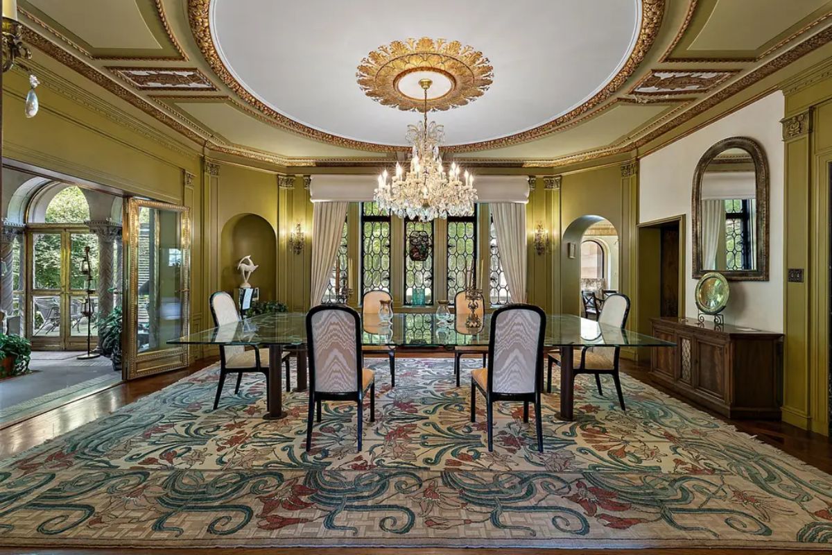 Dining room features a large glass table surrounded by elegant chairs.