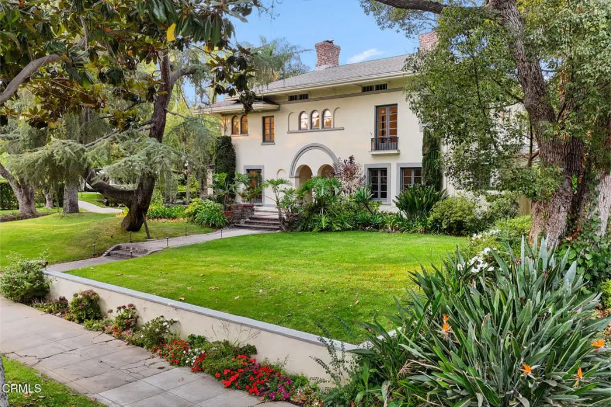 A two-story home with stucco walls and elegant arched windows.