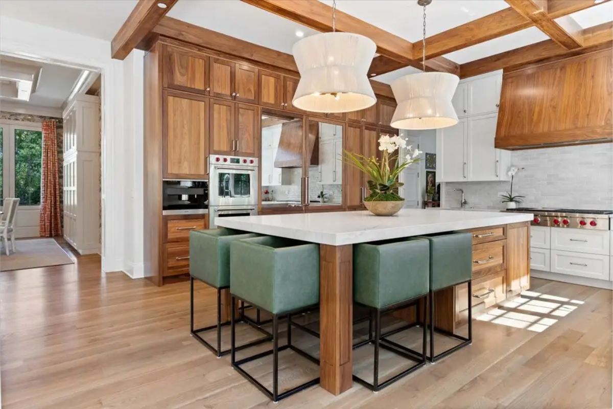 Kitchen designed with a combination of walnut cabinetry and white quartz countertops.