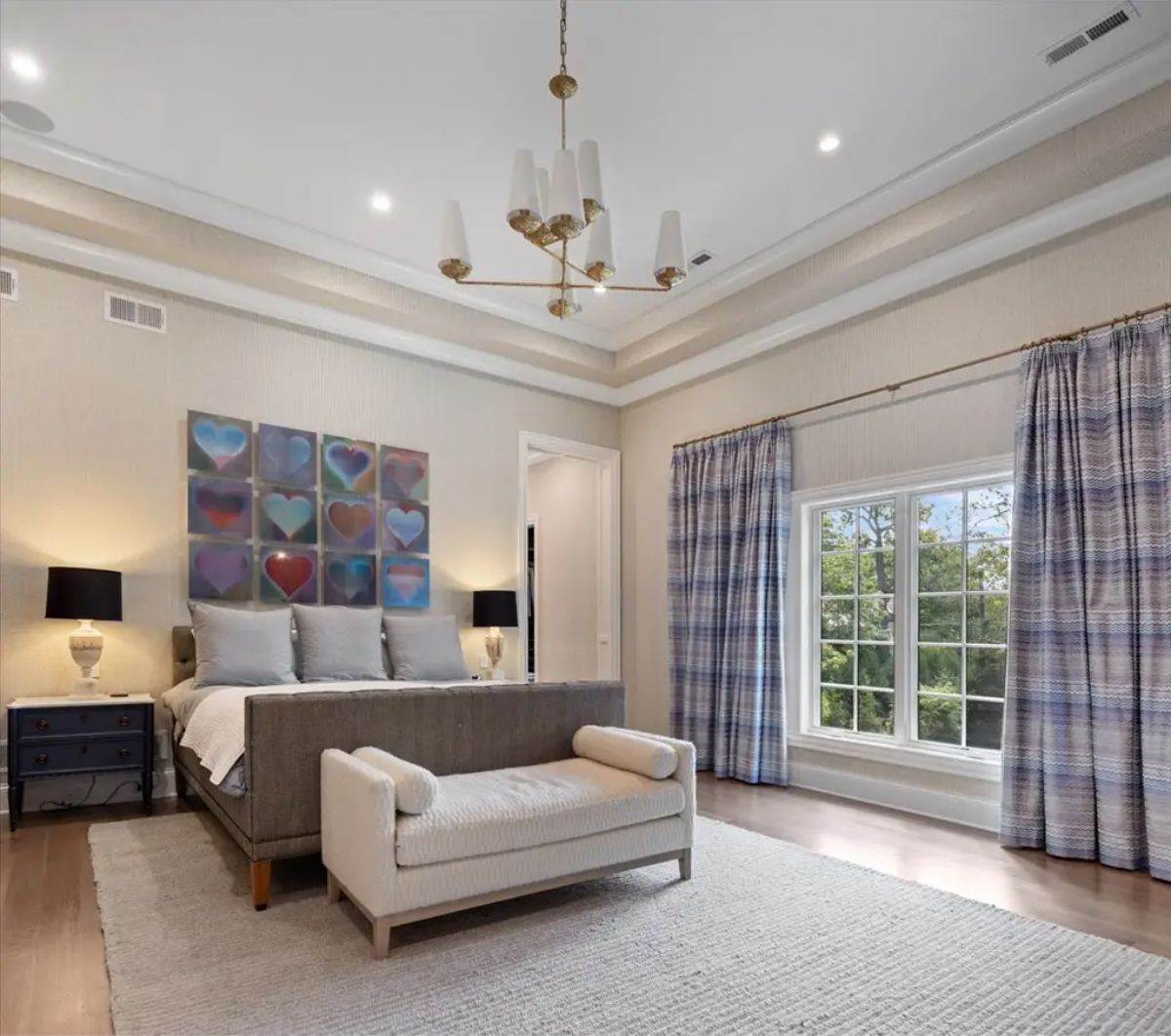 A neutral palette with soft, textured walls and a tray ceiling.