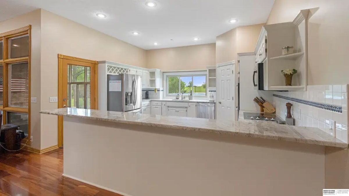 Modern kitchen with white cabinetry, granite countertops, and ample storage space.