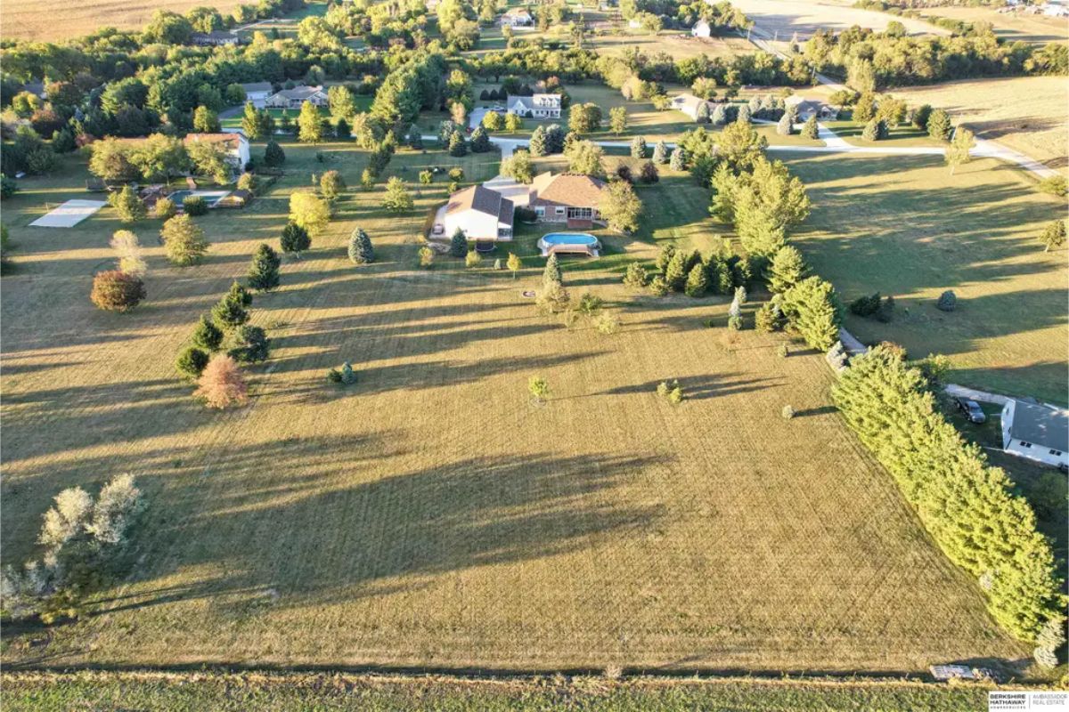 Aerial view of a sprawling property featuring nearly 5 acres of open, well-maintained land.