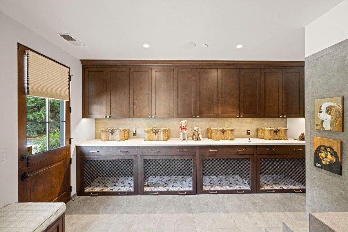 Custom-built pet room showcases cabinetry with mesh storage compartments and decorative pet portraits along the wall.
