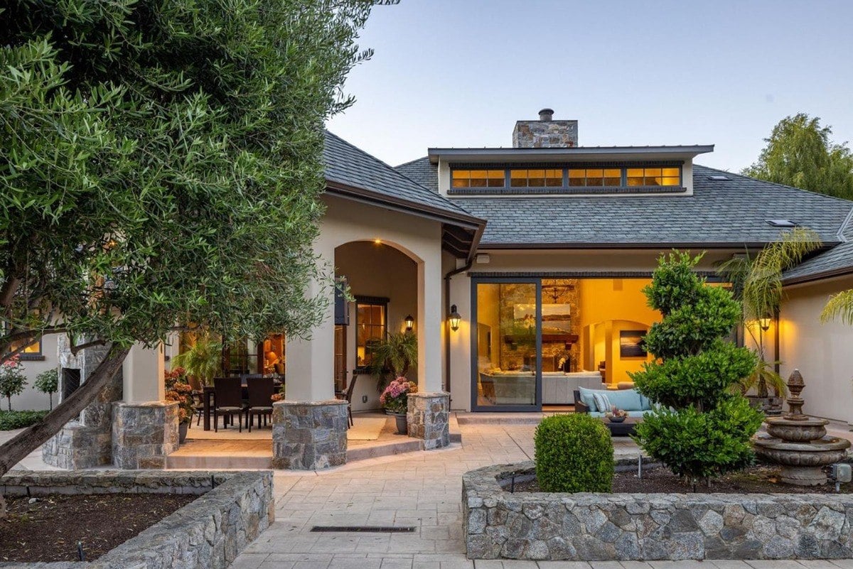 Open courtyard view showcases arched columns, modern windows, and decorative greenery.