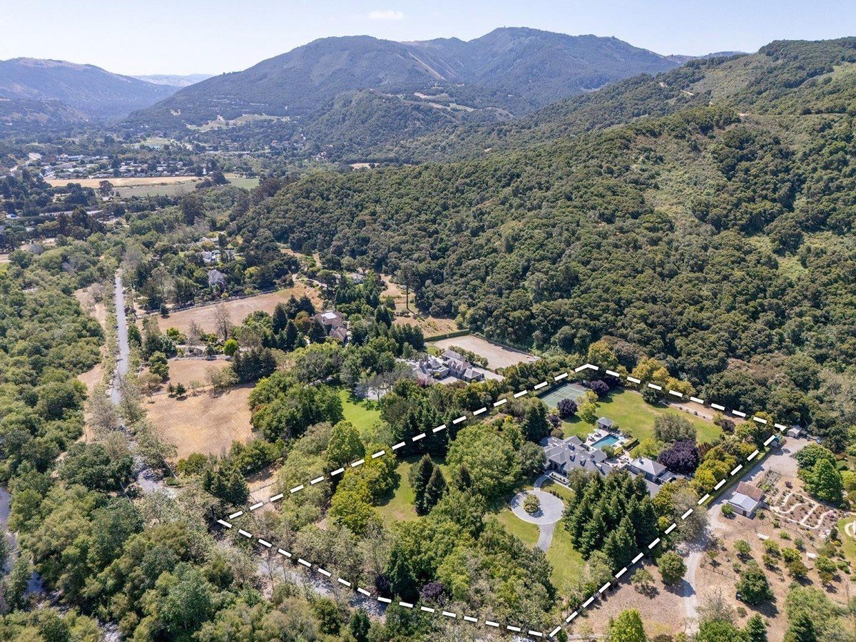 Panoramic shot of the surrounding landscape highlighting the vast area bordered by trees and hills.