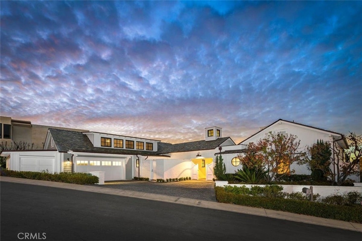 Twinkling evening sky highlights a beautifully designed property with a spacious driveway.