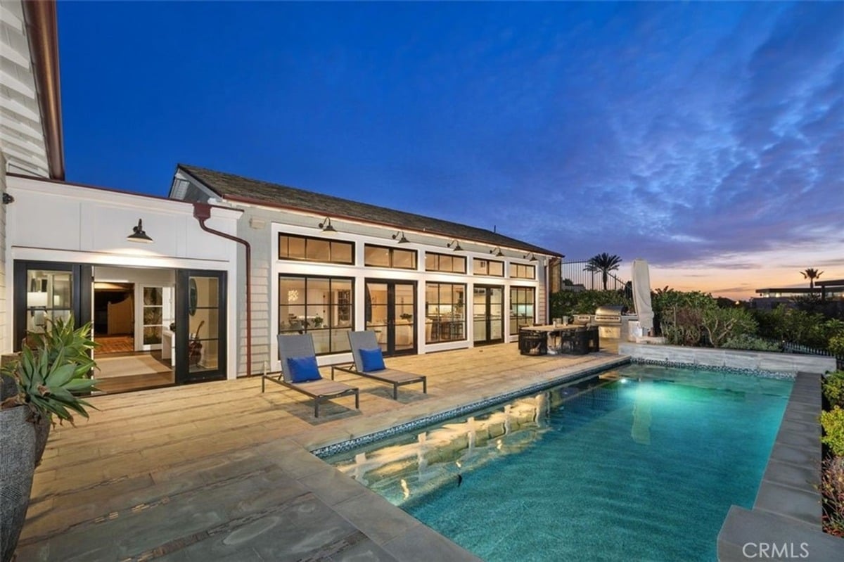 Inviting backyard with a swimming pool, lounge chairs, and a wooden deck.