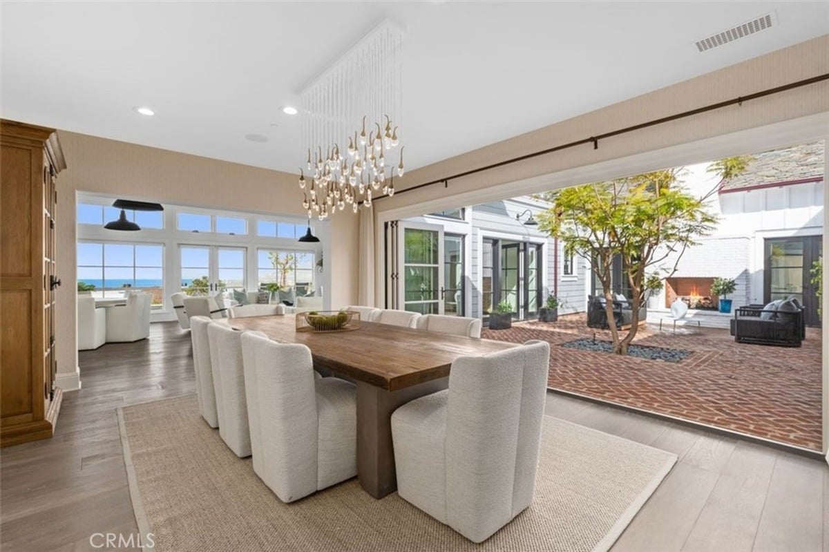 Dining area integrates indoor and outdoor spaces through large open doors.