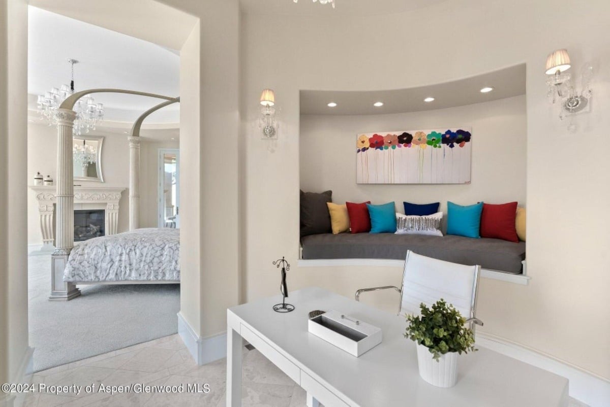 Cozy workspace features a built-in window seat adorned with colorful pillows for a playful touch.